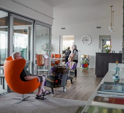 Image of modern lounge room with orange chair in the foreground